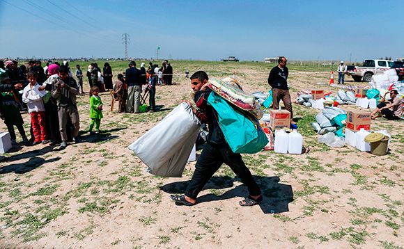 The burden of trauma: A displaced Iraqi fleeing IS trawls for aid. Photo: PJF MILITARY COLLECTION/ALAMY STOCK PHOTO, AHMAD GHARABLI/AFP/GETTY IMAGES
