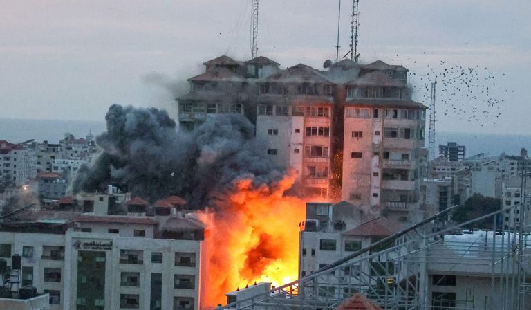 Smoke and flames rise from the base of a tower block struck amid Israeli bombardment of Gaza City.