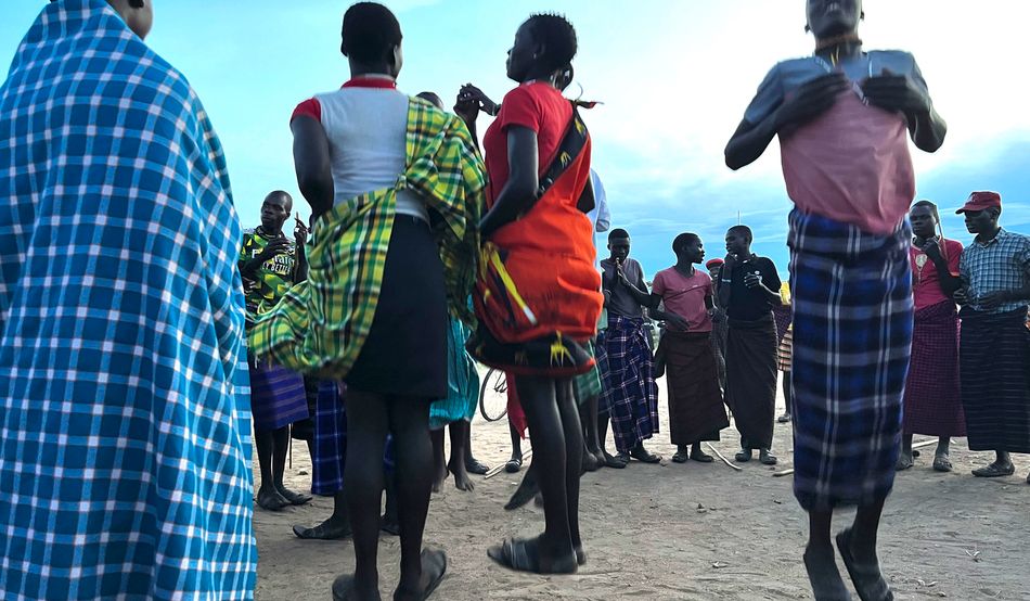 As the sun sets in Kotido, members of the community gather for a traditional dance celebration. (Sophie Neiman) 