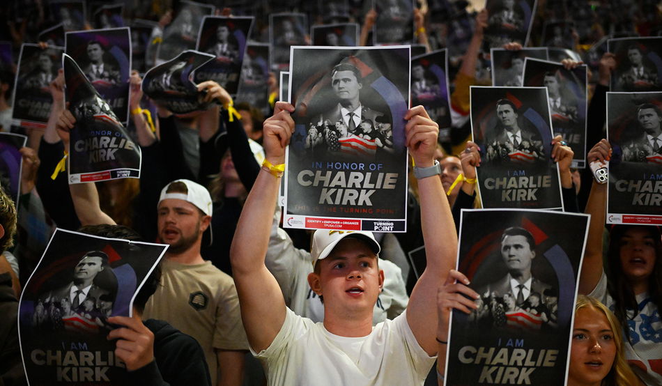 Attendees hold up posters of Charlie Kirk at a Turning Point USA rally at Utah State University, 30th September 2025. Image by Alamy/AP Photo/Alex Goodlett