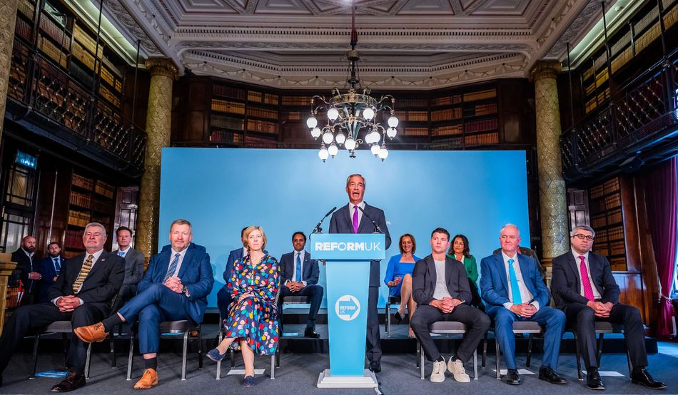 Nigel Farage addresses the press with new Reform mayors and councillors, as well as Reform MP Sarah Pochin, after the local elections in May. Image: Guy Bell / Alamy