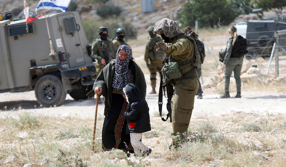 The Israeli army forcing Palestinians to leave their structures in the Masafer Yatta village of Khallet al-Dabaa last May. Image: Xinhua / Alamy
