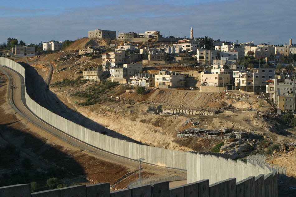 The wall separating Israel (left) and Palestine (right) through communities in Jerusalem and throughout the West Bank. Image: Andrew Aitchison / Alamy