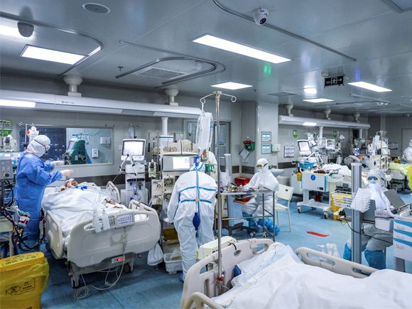 Before the vaccine: medical staff treat patients infected by coronavirus at a hospital in Wuhan © STR/AFP via Getty Images