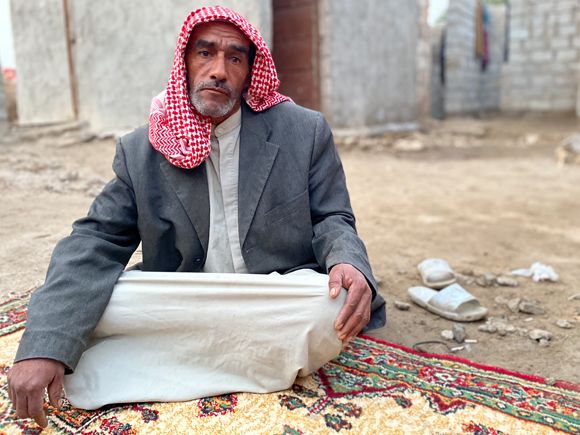 Enhaira's son, Saad Aouni, sits outside his home in Al Hilal, Muthanna province, January 2023