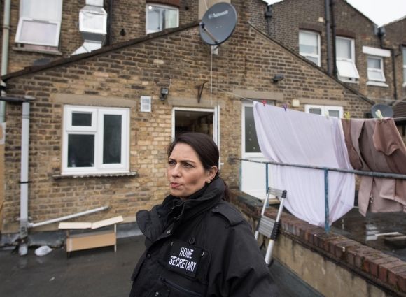Where it all ends? Hardline home secretary Priti Patel has taken to attending immigration busts in a specially made police-style jacket. © PA Images / Alamy Stock Photo