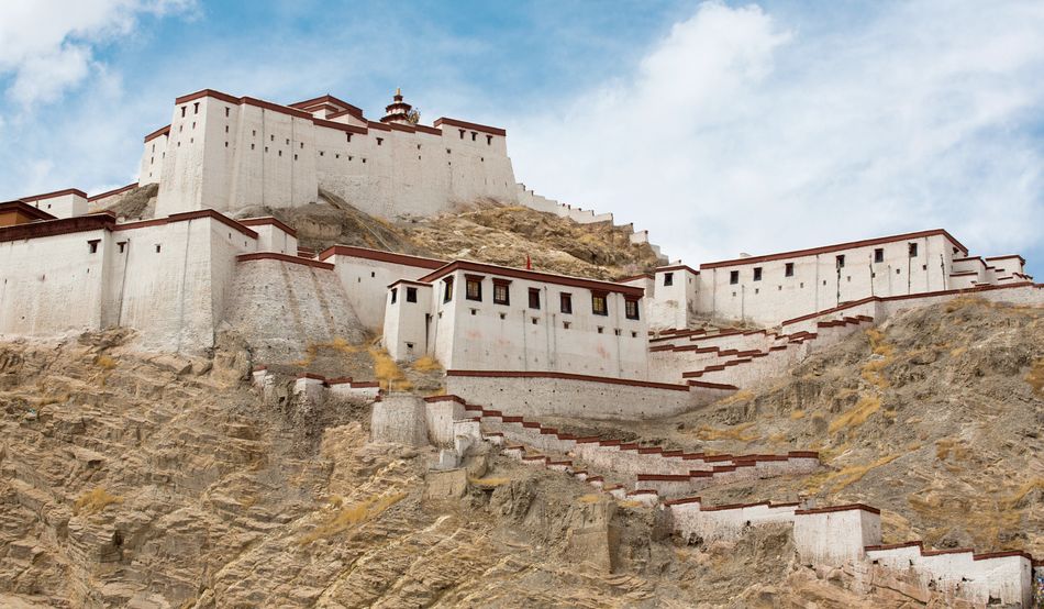 The historic home of the Dalai Lama in Lhasa, Tibet. Sitting on top of a rock, it is a white building with a red line along the top of walls, which are high and straight. It looks like a fortress. Contributor: Panther Media Global / Alamy Stock Photo