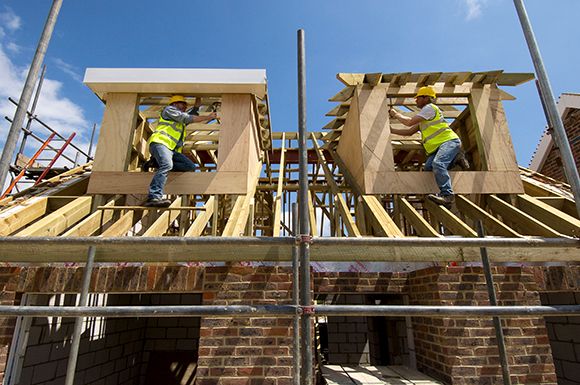 Carpenters working on the roof of a new house