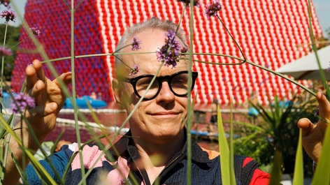 Hans Ulrich Obrist outside “The London Mastaba” installation by Christo and Jeanne-Claude, commissioned by the Serpentine Gallery in 2018. Image: Martin Parr / Magnum Photos